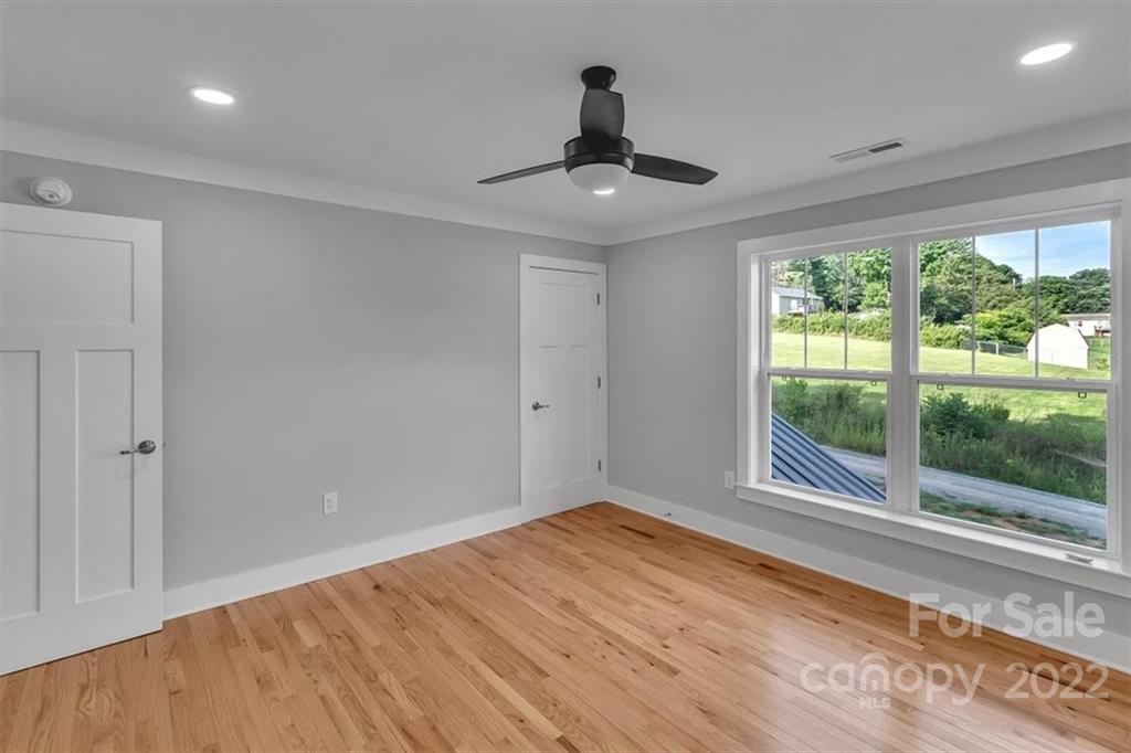 225 Ridge View Drive, Unit 16 Clyde, NC 28721 - Photo 23 of 29 a view of an empty room with wooden floor and a window