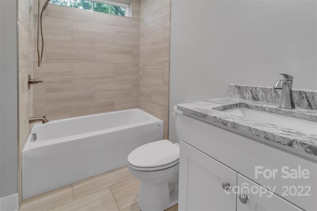 225 Ridge View Drive, Unit 16 Clyde, NC 28721 - Photo 26 of 29 a bathroom with a granite countertop toilet sink and bathtub