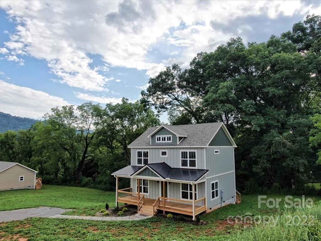 225 Ridge View Drive, Unit 16 Clyde, NC 28721 - Photo 8 of 29 a house with tall trees in the background