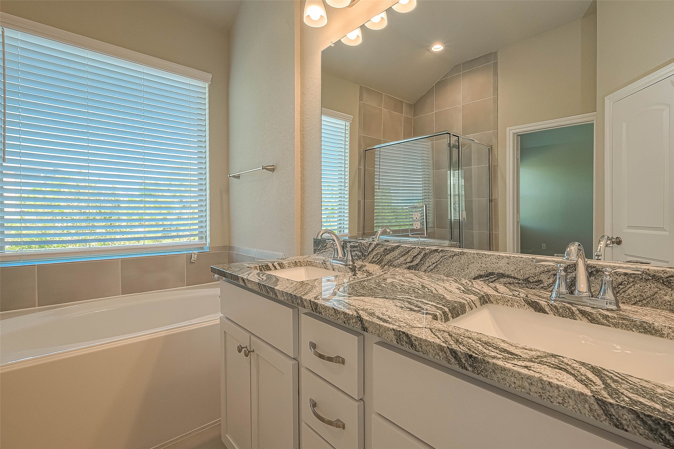 16111 Northern Cardinal Lane Cypress, TX 77433 - Photo 16 of 29 a bathroom with a granite countertop sink and a bathtub
