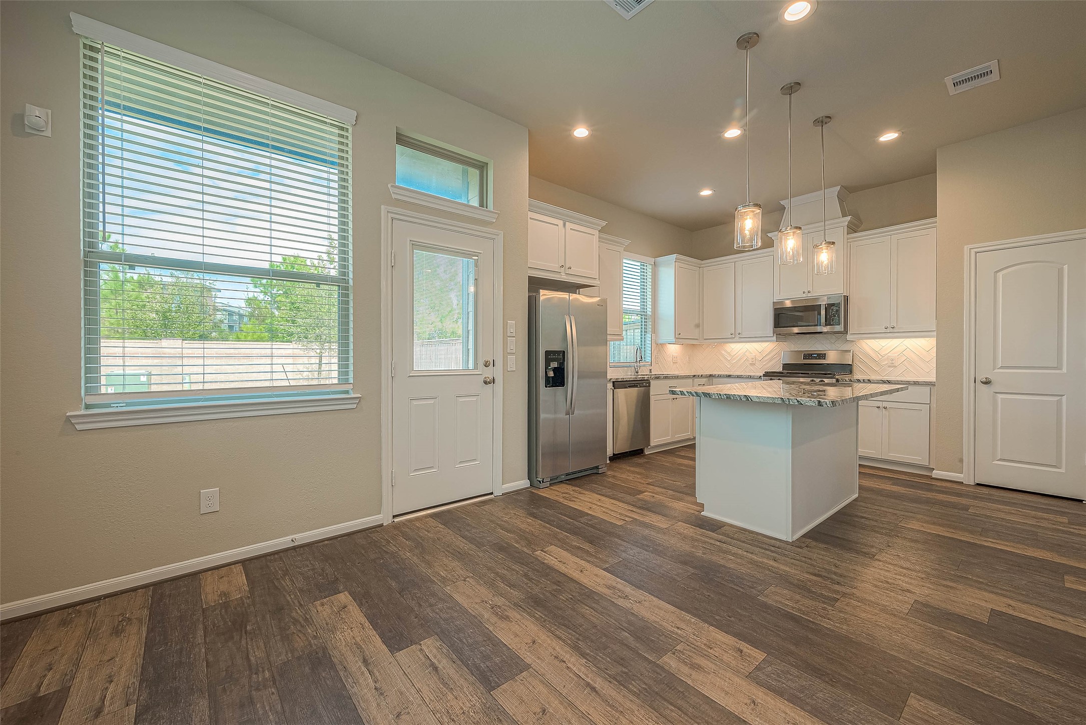 16111 Northern Cardinal Lane Cypress, TX 77433 - Photo 6 of 29 a view of kitchen with kitchen island white cabinets and stainless steel appliances