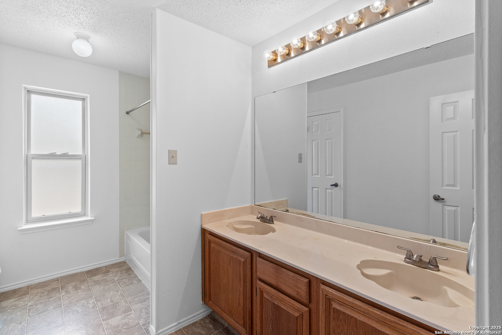 25002 Silverstone San Antonio, TX 78258 - Photo 20 of 26 a bathroom with a sink and a mirror