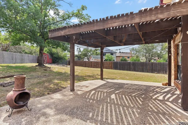 a view of a patio with table and chairs under an umbrella