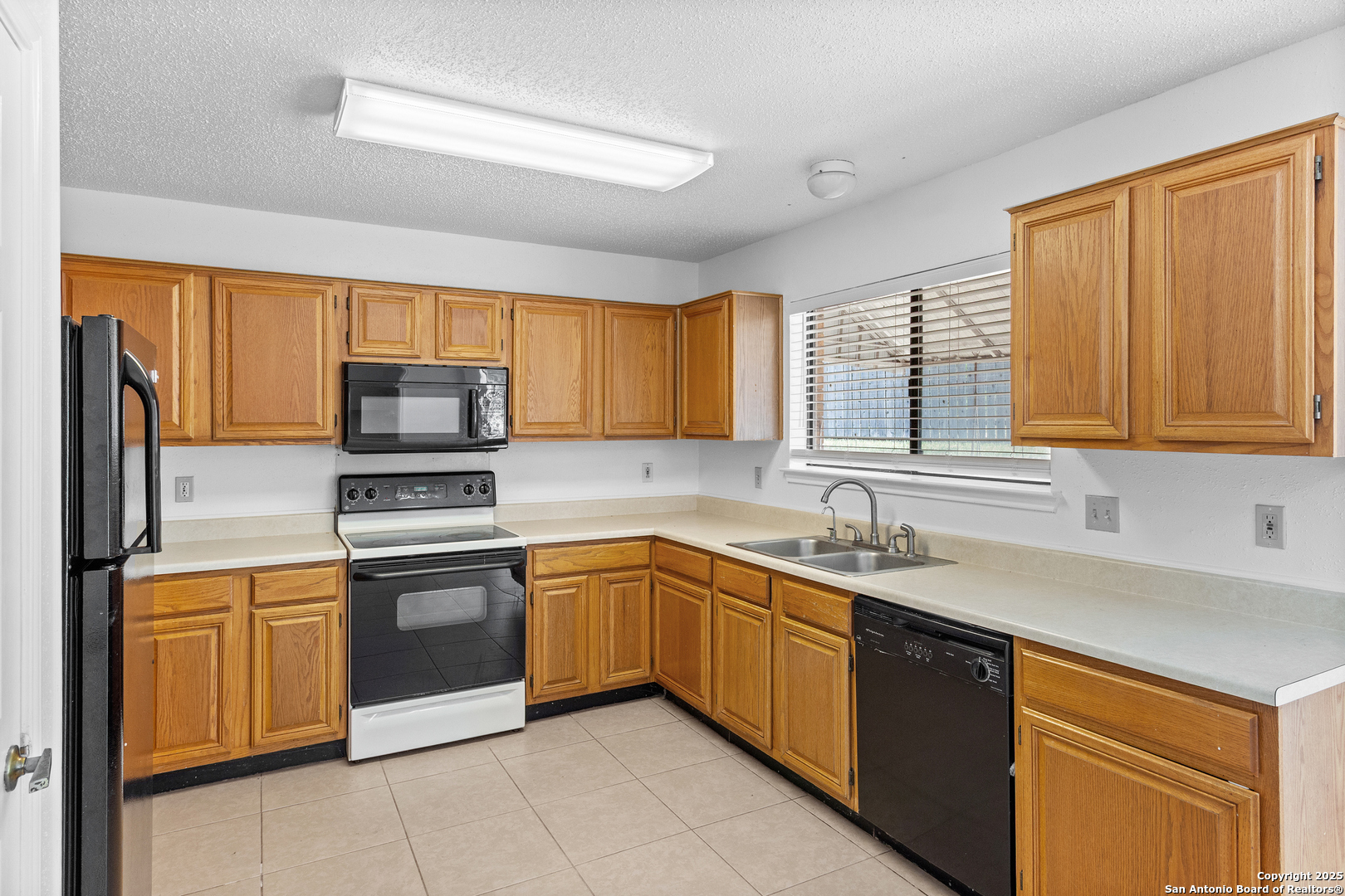 25002 Silverstone San Antonio, TX 78258 - Photo 6 of 26 a kitchen with stainless steel appliances granite countertop a sink stove and refrigerator