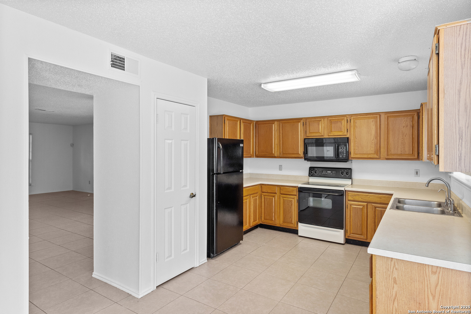 25002 Silverstone San Antonio, TX 78258 - Photo 7 of 26 a kitchen with stainless steel appliances granite countertop a refrigerator and a sink