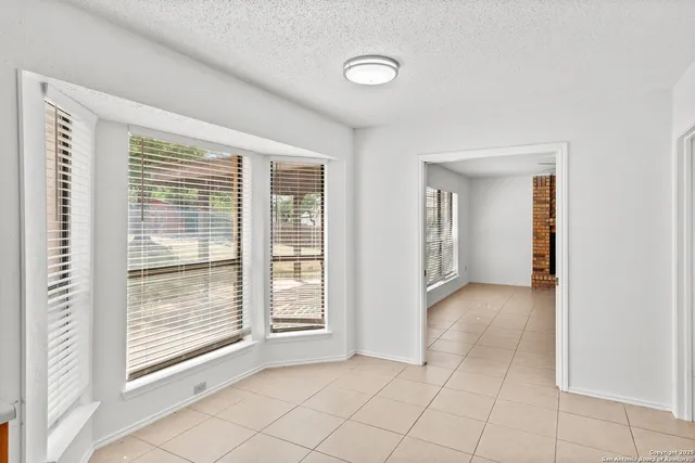 a view of an empty room with window and a fireplace