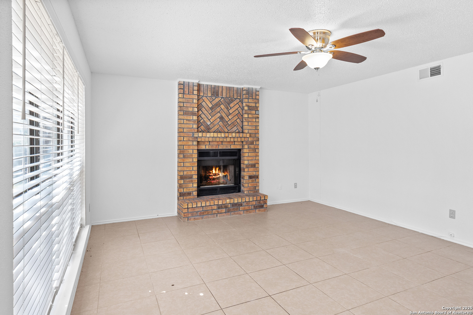 25002 Silverstone San Antonio, TX 78258 - Photo 9 of 26 an empty room with windows and fireplace