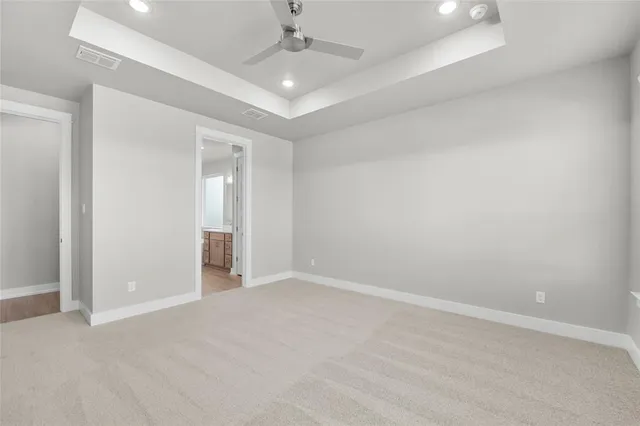 an empty room with a ceiling fan and closet area