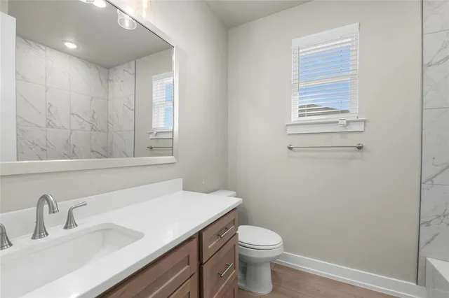 a bathroom with a sink a toilet and window
