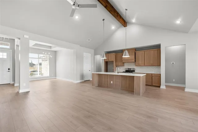 a large kitchen with stainless steel appliances kitchen island a large counter top and a wooden floors