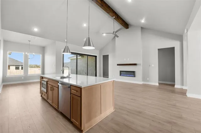 a large kitchen with stainless steel appliances granite countertop a stove and a refrigerator