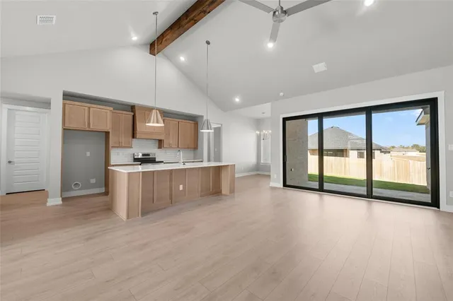 a large kitchen with a large counter top appliances and cabinets
