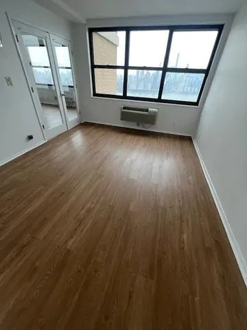 wooden floor in an empty room with a window