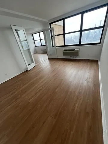 wooden floor in an empty room with a window