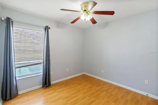 an empty room with a window and a fan