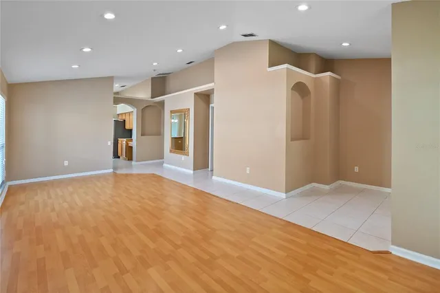 a view of an empty room with wooden floor