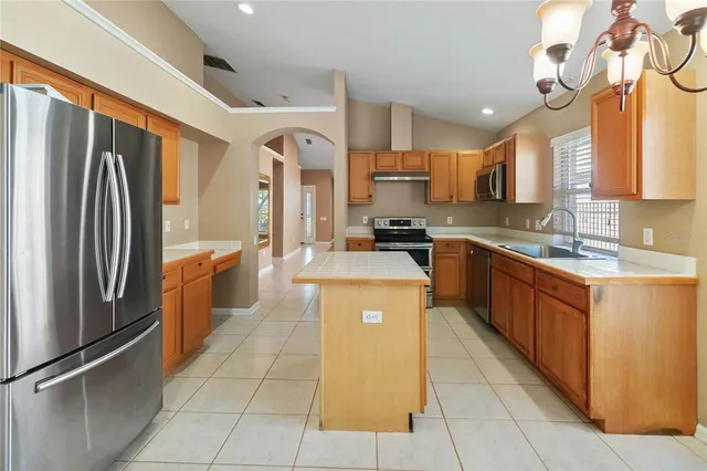 a large kitchen with stainless steel appliances granite countertop a stove a sink dishwasher and a refrigerator