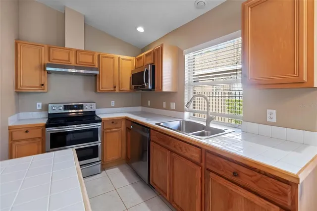 a kitchen with a sink stove top oven and cabinets