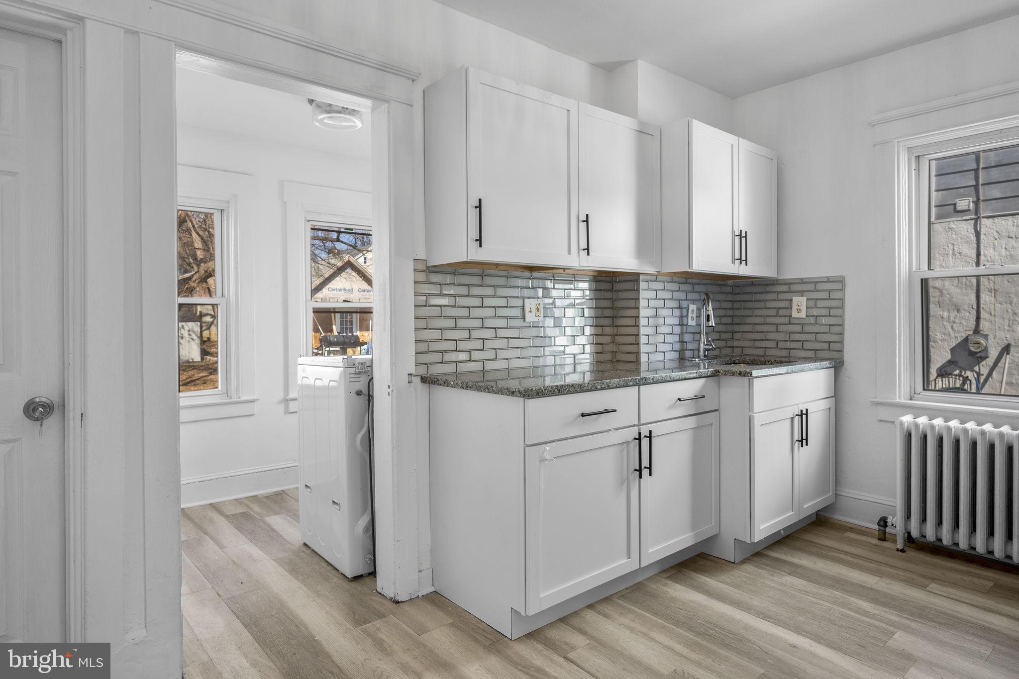 246 Powell Road Springfield, PA 19064 - Photo 7 of 29 a kitchen with white cabinets and window