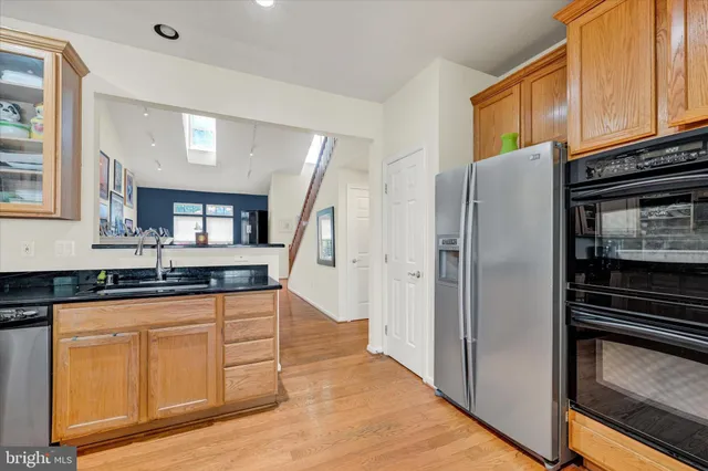 a kitchen with granite countertop a refrigerator stove and sink