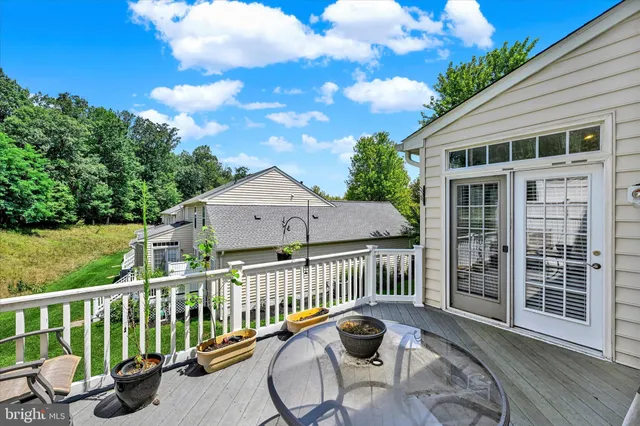 a view of a house with wooden deck and furniture
