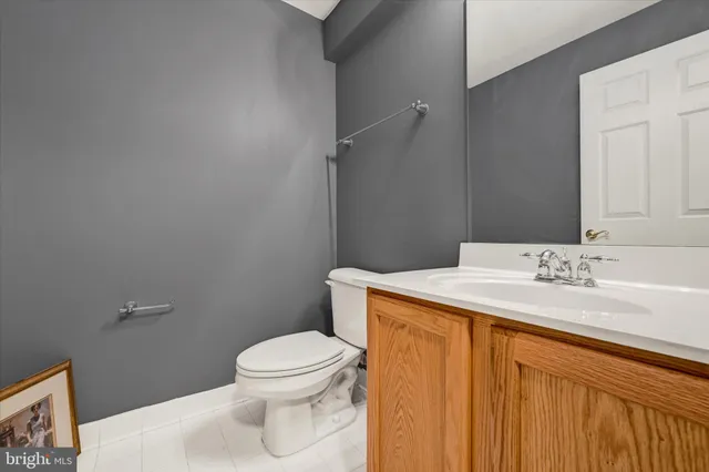 a bathroom with a granite countertop sink toilet and a mirror