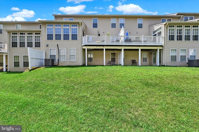 a view of a building with a big yard and large trees