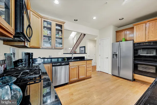 a kitchen with stainless steel appliances granite countertop a refrigerator and a stove top oven