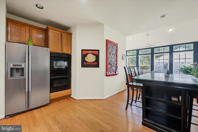 a kitchen with stainless steel appliances granite countertop a refrigerator and a table