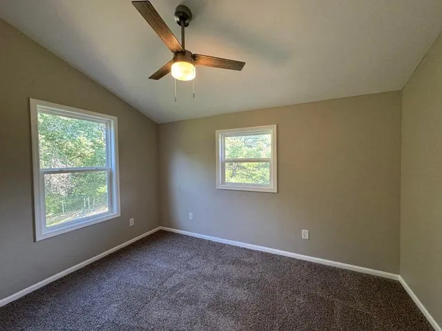 a very nice looking room with window and ceiling fan