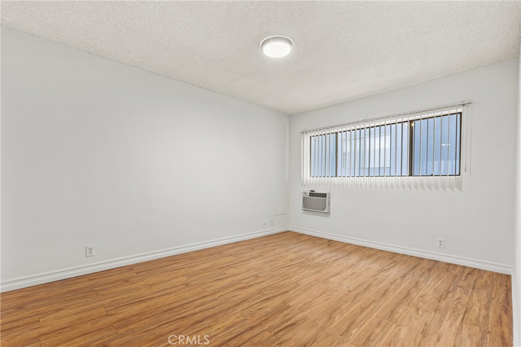 4924 Kester Avenue, Unit 10 Sherman Oaks, CA 91403 - Photo 13 of 17 a view of an empty room with wooden floor and a window