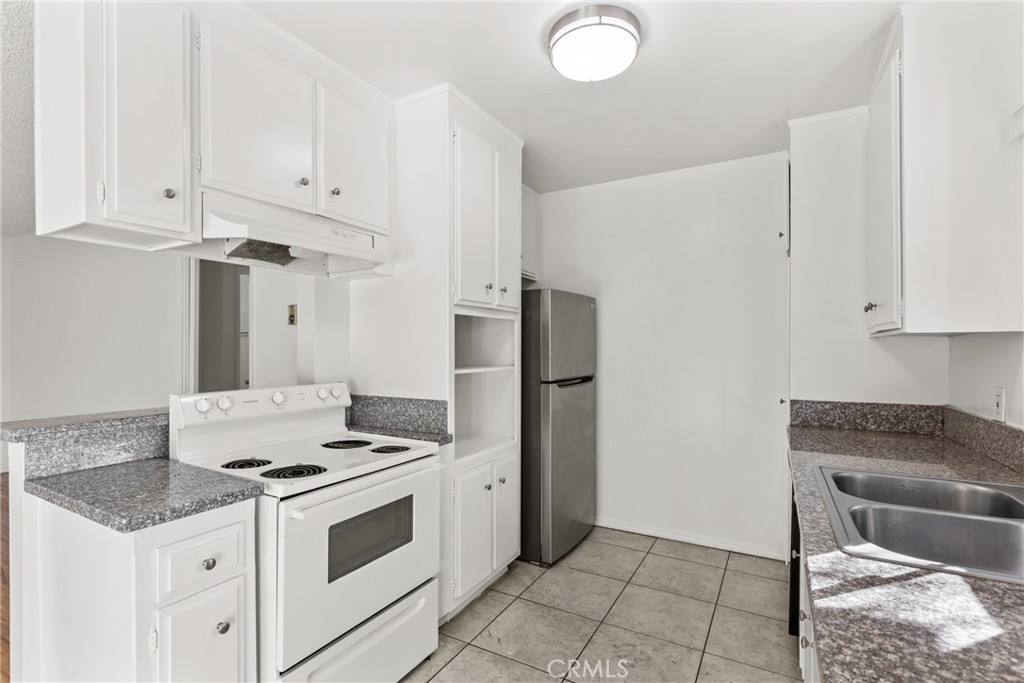 4924 Kester Avenue, Unit 10 Sherman Oaks, CA 91403 - Photo 7 of 17 a kitchen with granite countertop a sink stove and refrigerator