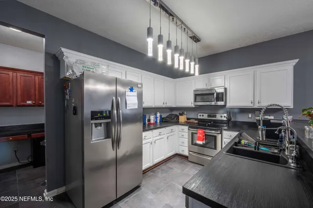 a kitchen with stainless steel appliances a refrigerator a stove a microwave and cabinets
