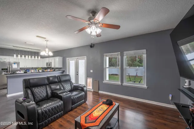 a kitchen with stainless steel appliances granite countertop a refrigerator a sink dishwasher a stove and a refrigerator with wooden floor