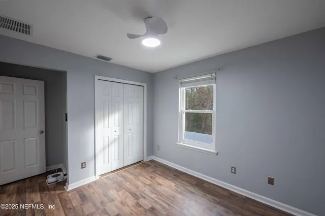 an empty room with windows and closet