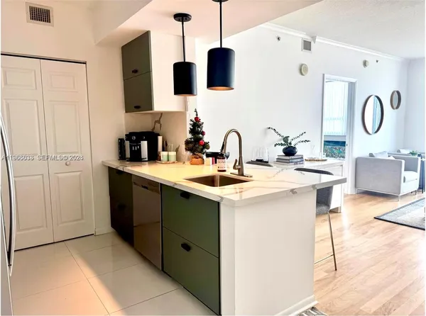 a kitchen with a sink cabinets and wooden floor