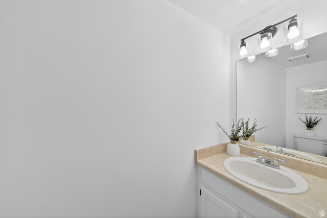 788 East Gables Street Midvale, UT 84047 - Photo 13 of 24 Vanity featuring a built-in oval sink, light-toned countertop, and white cabinetry