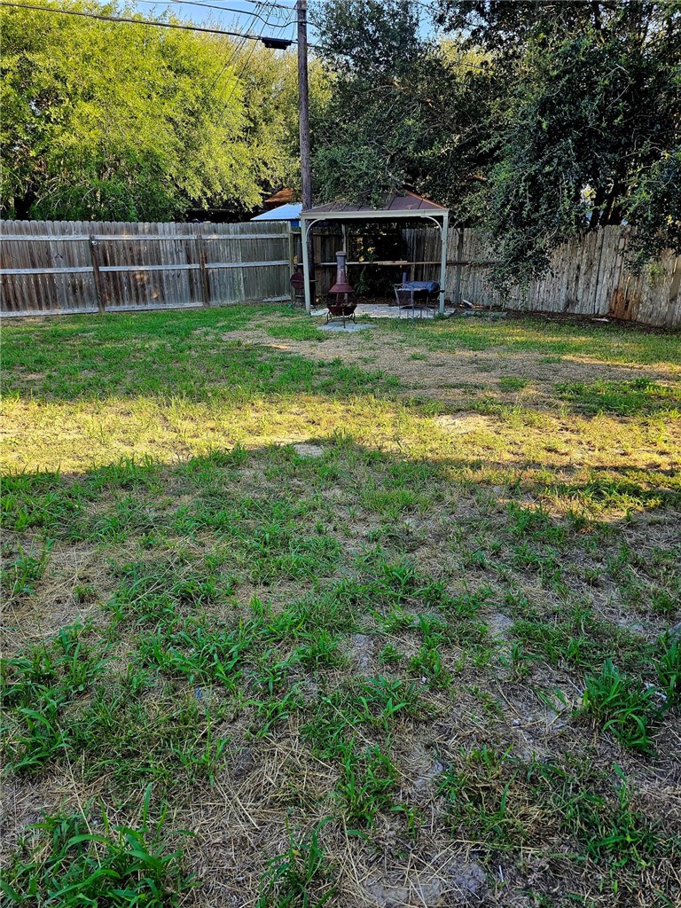 2313 Retta Drive Corpus Christi, TX 78418 - Photo 6 of 18 a view of a backyard with wooden fence and a large tree