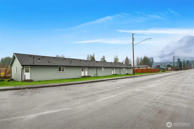 a view of a road with a big yard and palm tree