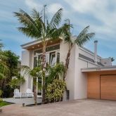 a front view of a house with a tree