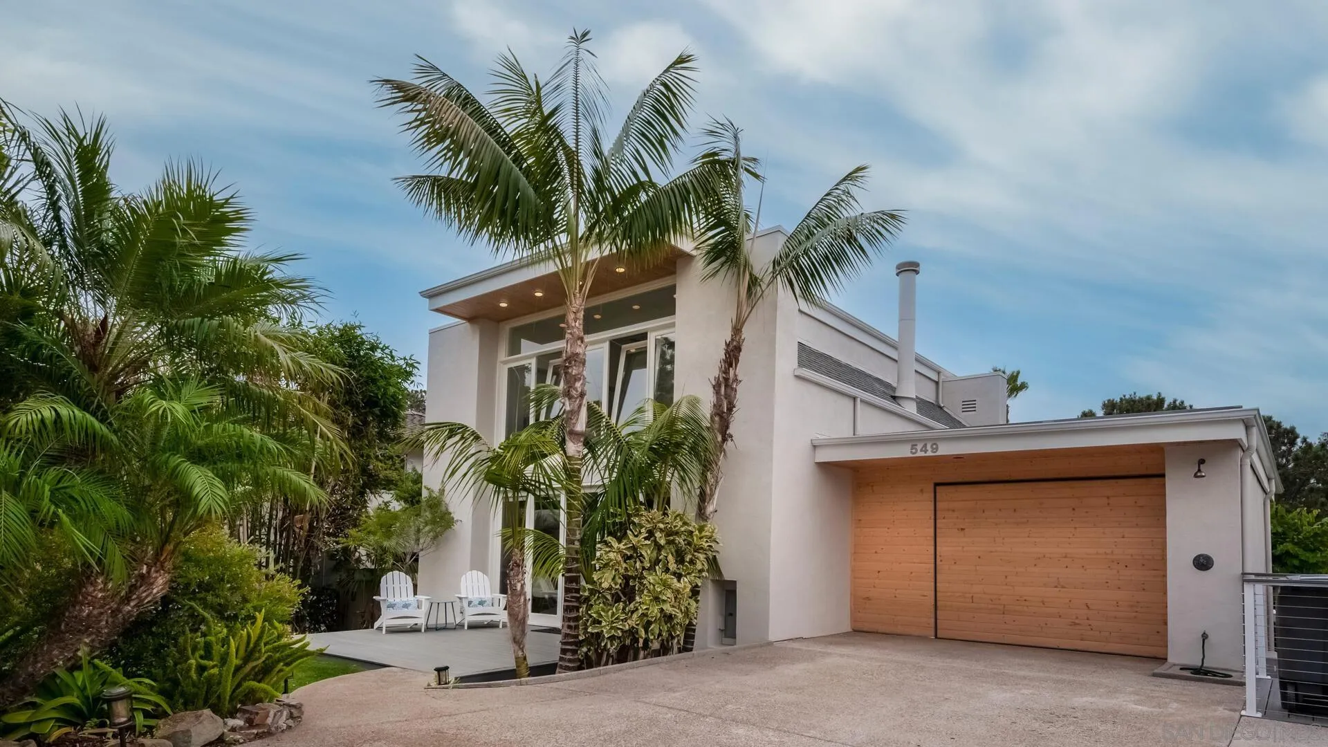 a front view of a house with a tree