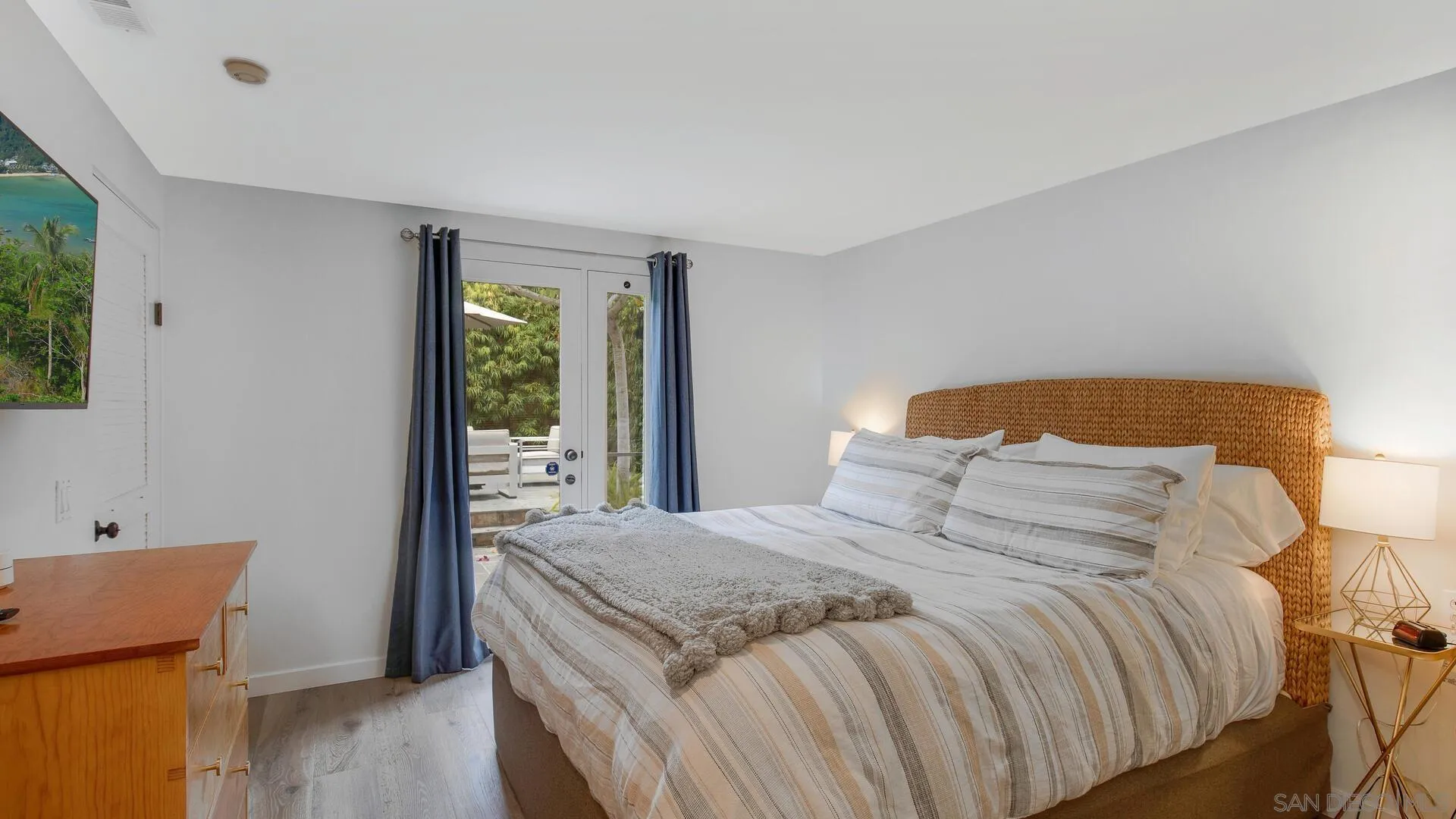 549 Rimini Road Del Mar, CA 92014 - Photo 24 of 32 a bedroom with a bed and wooden floor