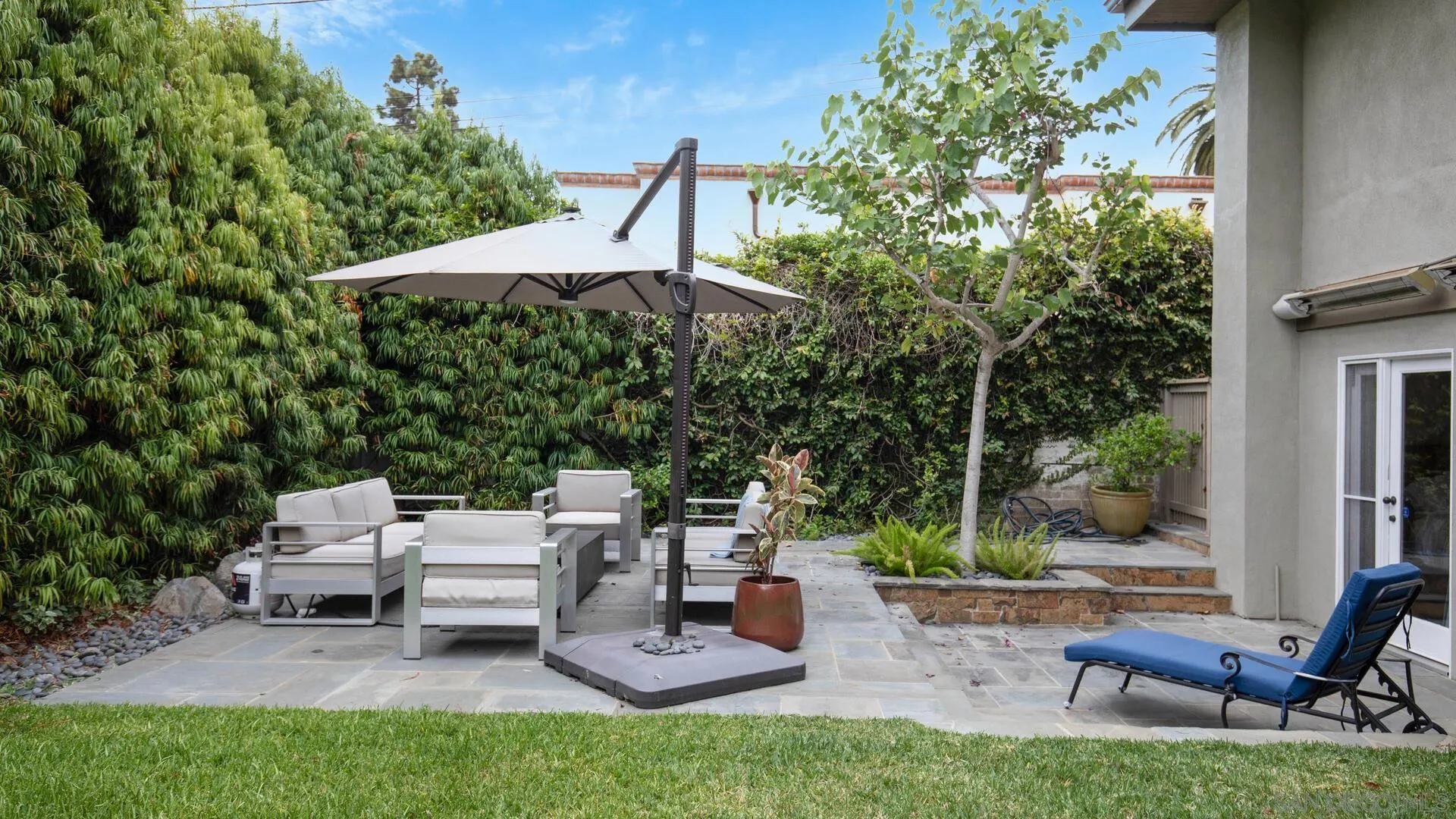 549 Rimini Road Del Mar, CA 92014 - Photo 31 of 32 a view of a patio with table and chairs under an umbrella