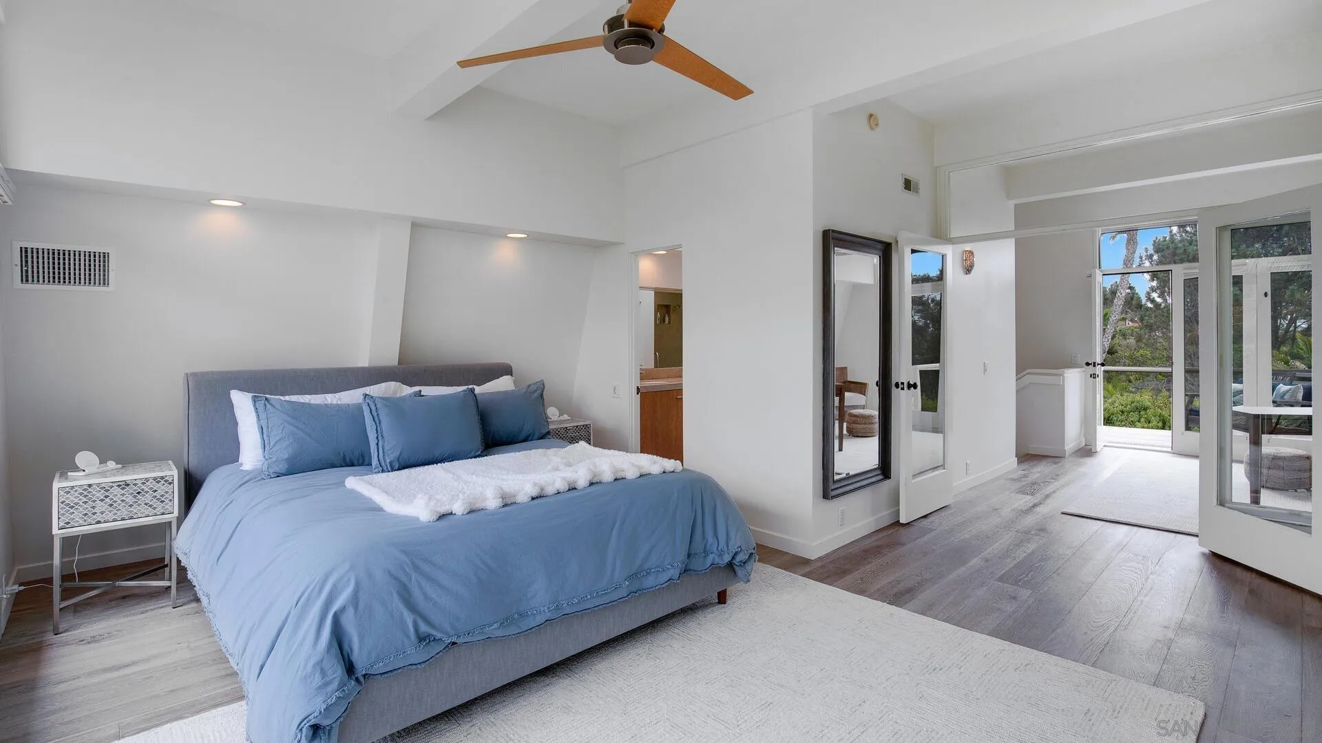 549 Rimini Road Del Mar, CA 92014 - Photo 8 of 32 a large bedroom with a bed and wooden floor