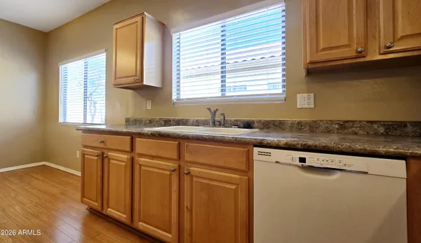 a kitchen with granite countertop wooden cabinets stainless steel appliances a sink and a window