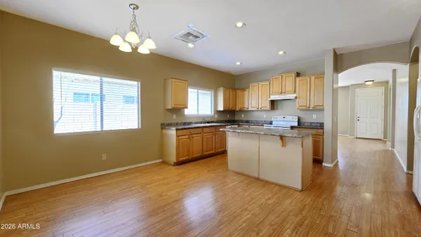 a kitchen with granite countertop wooden floors stainless steel appliances and window