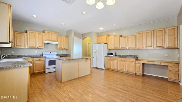 a kitchen with a refrigerator stove top oven and cabinets