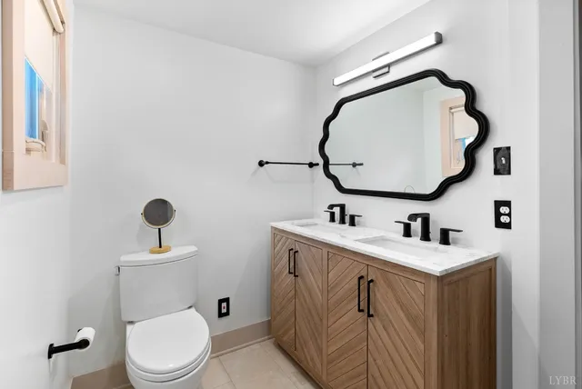 a bathroom with a toilet sink vanity and mirror