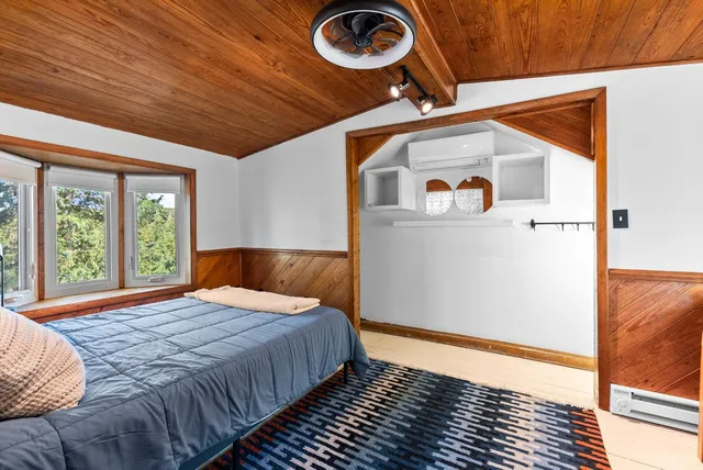 a bathroom with a toilet a sink a mirror and a window