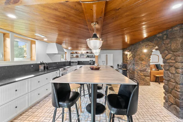 a kitchen with granite countertop a sink a stove and cabinets